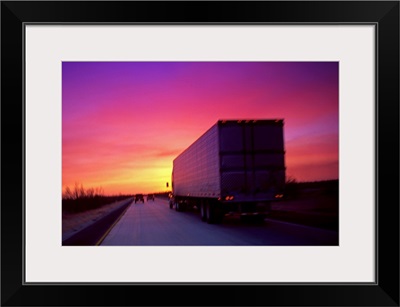 Semi-truck on road at sunset