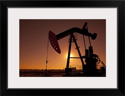 Silhouette of oil pump jack on rig