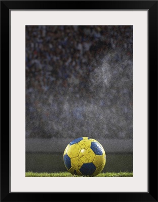 Soccer ball on field in rain
