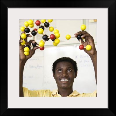 Teenage boy viewing molecule model
