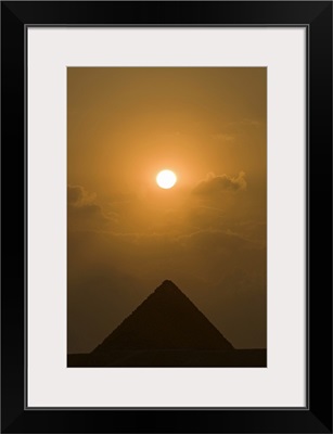 The sun begins to set above The Great Pyramid of Giza, in Cairo, Egypt.