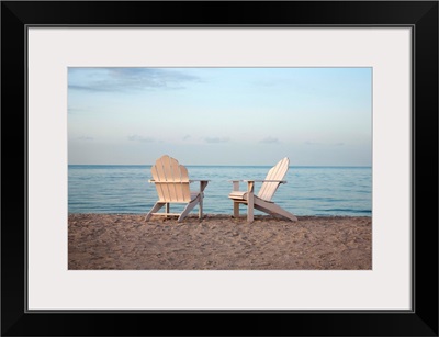 Two adirondack chairs on the beach