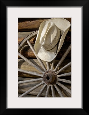 Wagon wheel and cowboy hat by log cabin, California, USA