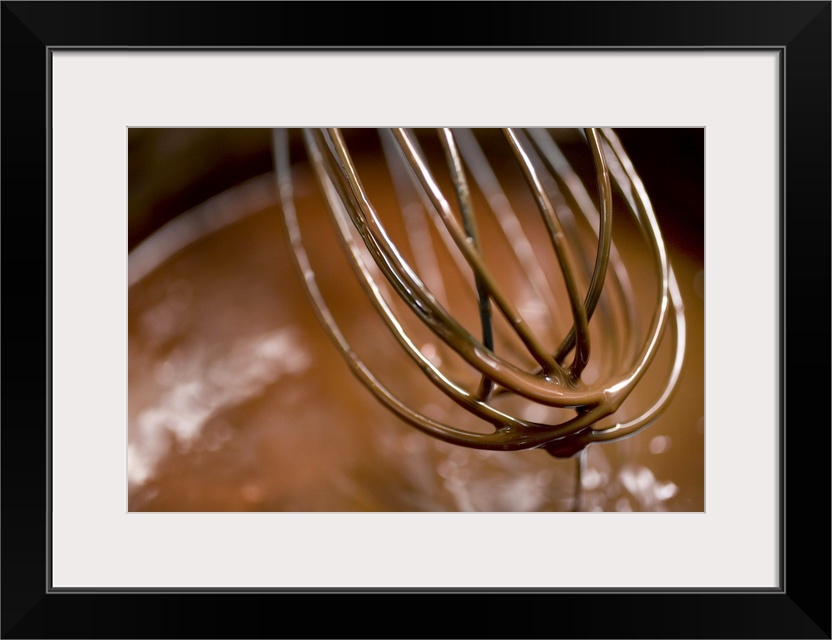 Whisking the chocolate in a saucepan to melt the larger pieces