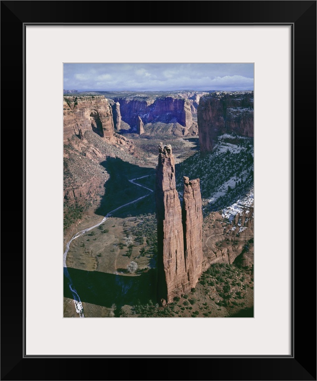 A photograph of a towering rock formation in a desert canyon.