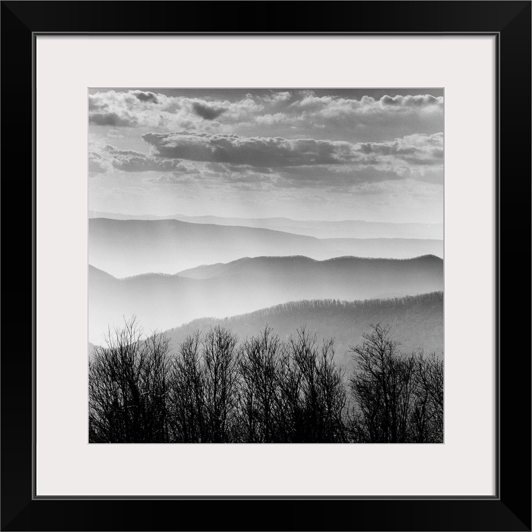 Square black and white image of the rolling mountains of the Blue Ridge with mist and layers of clouds.