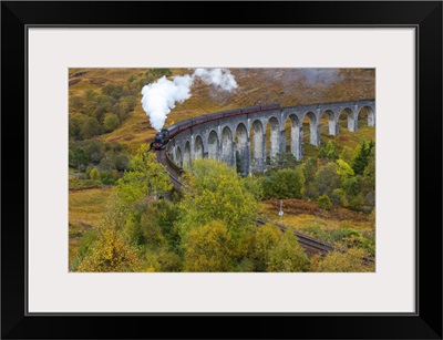 Steam train crossing Glenfinnan viaduct, Lochaber, Highlands, Scotland, UK