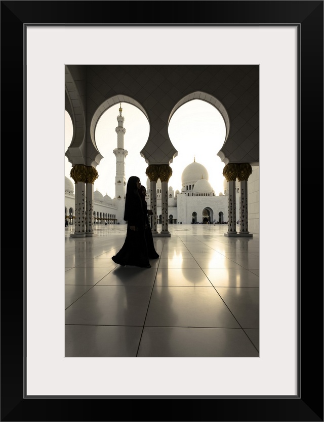United Arab Emirates, Abu Dhabi. Arabic women walking inside Sheikh Zayed Grand Mosque at sunset