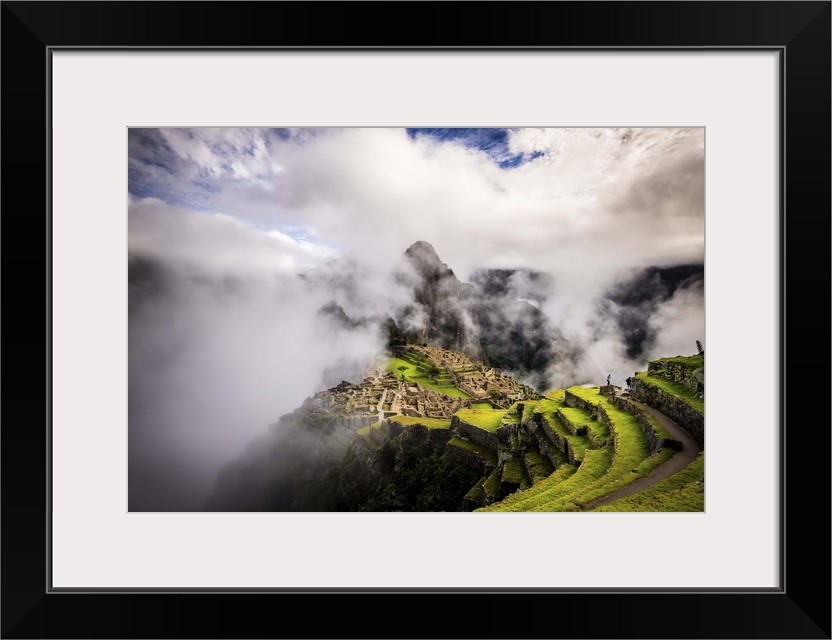 Morning rain clouds break letting in golden light, Machu Picchu, Peru