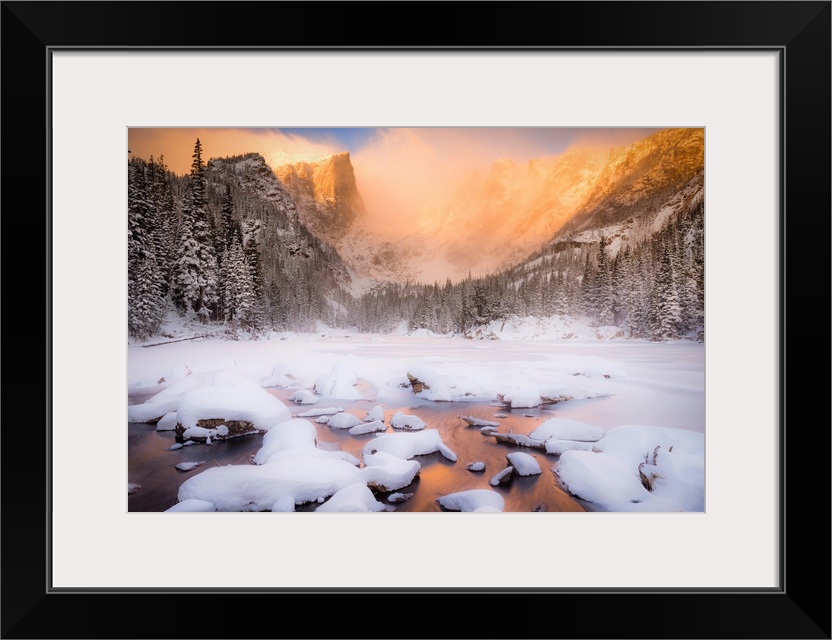 Giant photograph of a snow covered landscape filled with trees surrounding and a frozen river running down the center of t...