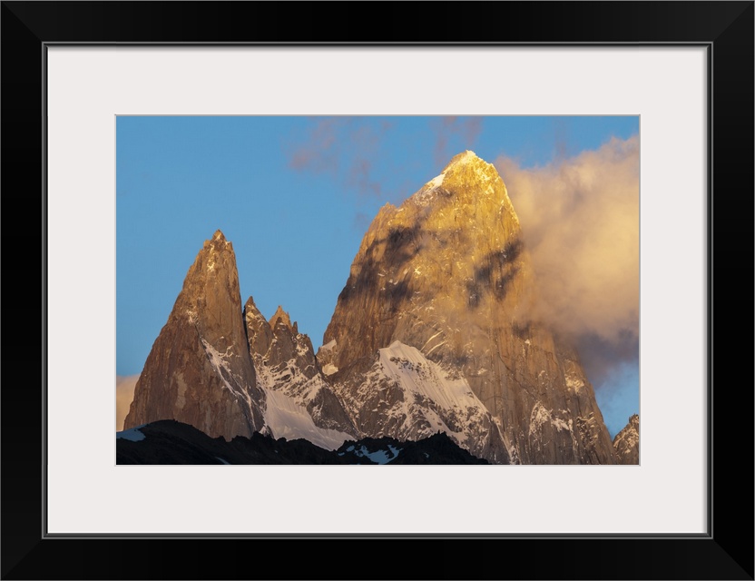 Photograph of mountain spires in South America, with clouds moving in to the frame of the image.