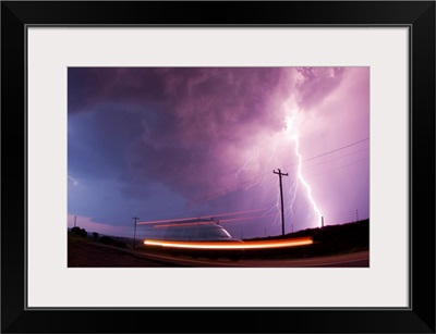 A large lightning bolt strikes behind a storm chaser's moving van