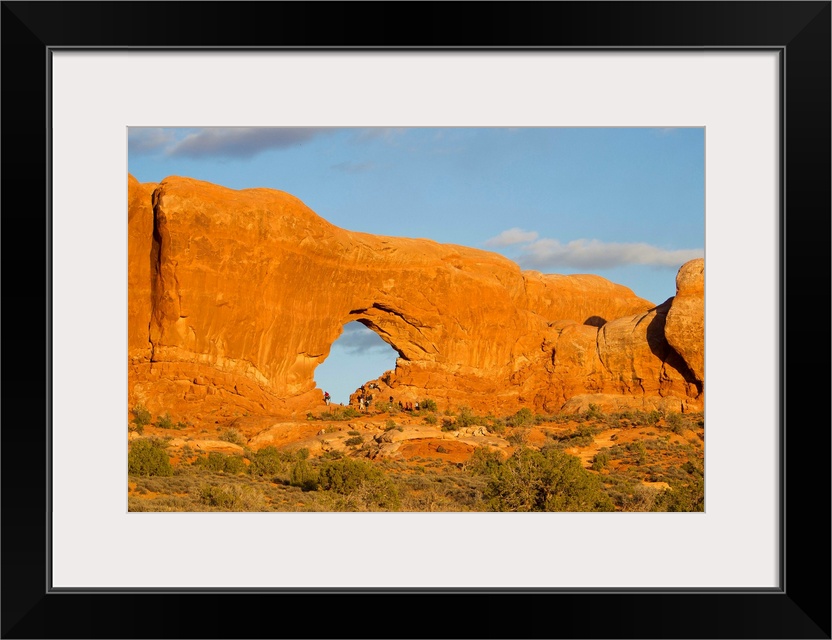 A rock wall formation with a large hole in it.