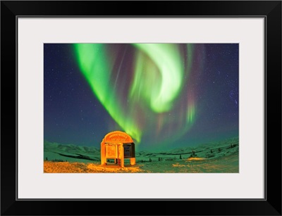 An aurora borealis near the famous Arctic Circle sign
