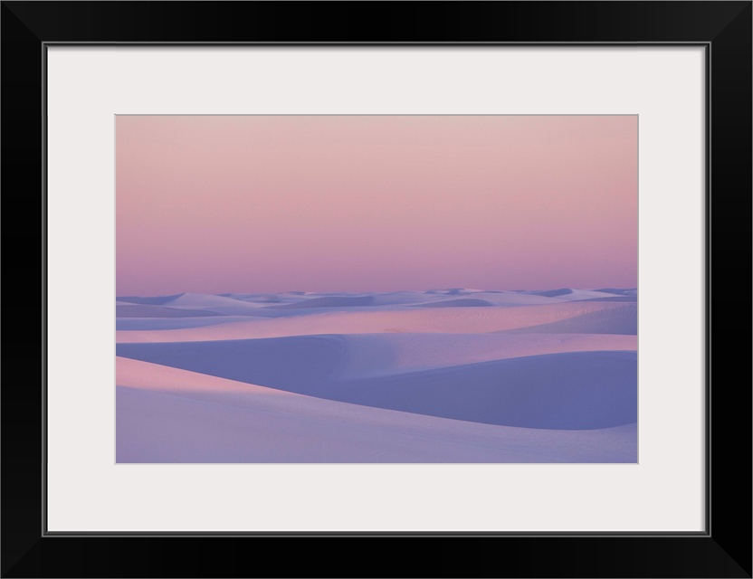 Pink and purple illuminated sand dunes during sunset.