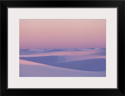 Pink and purple illuminated sand dunes during sunset