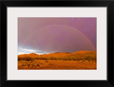 Rainbow and purple sky on the backside of thunderstorm in a desert