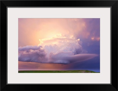 Sunset paints a decaying thunderstorm and the sky a glowing purple and pink