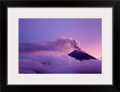 The cloud-shrouded Tungurahua volcano erupting at twilight