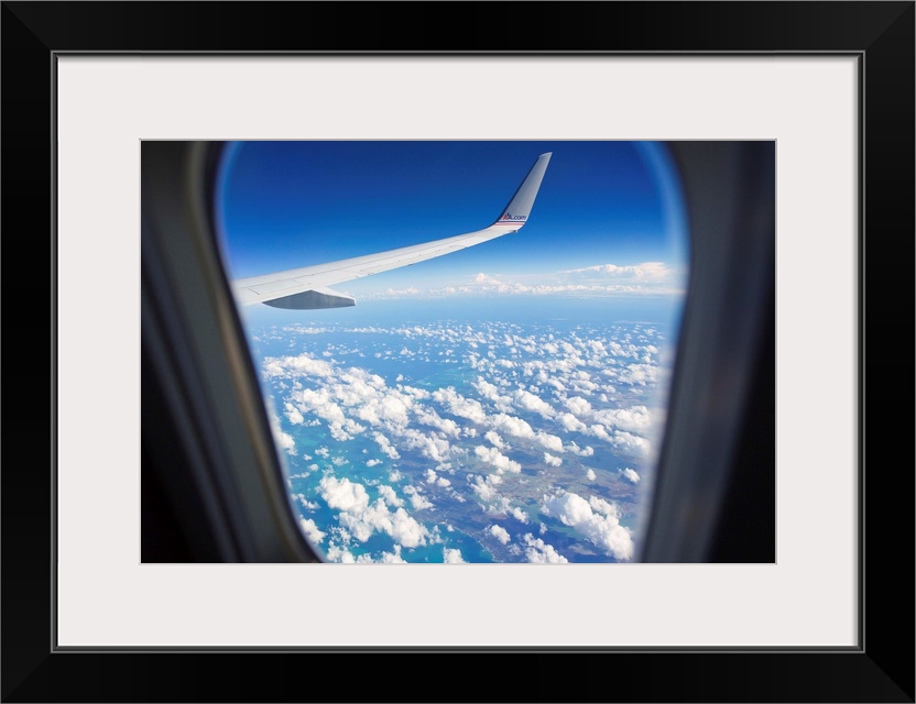 View through a passenger airplane window flying over the Caribbean.