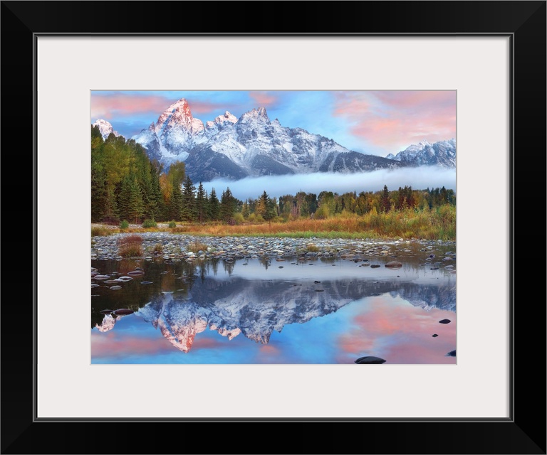 Giant photograph incorporates a large mountain range covered in snow reflecting over a calm body of water surrounded by a ...