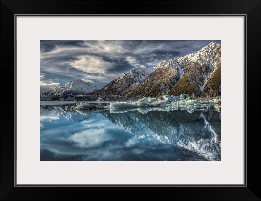 Mirror image, reflection of clouds, peaks and icebergs in Tasman Glacier Lake, Mount Cook National Park, New Zealand