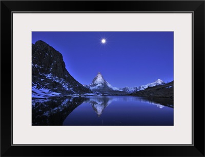 The Matterhorn reflected in the Riffelsee Lake under a full moon, Switzerland