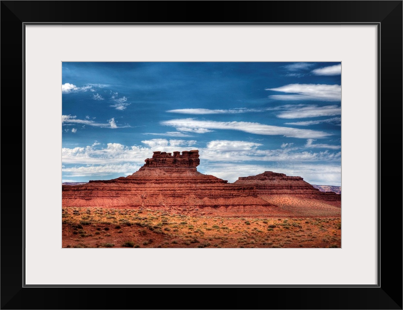 A photograph of red desert landscape with an intricate rock formation in the distance.