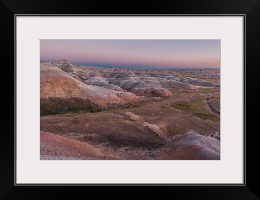 Sunset over layered rock formation in Badlands National Park, South Dakota.