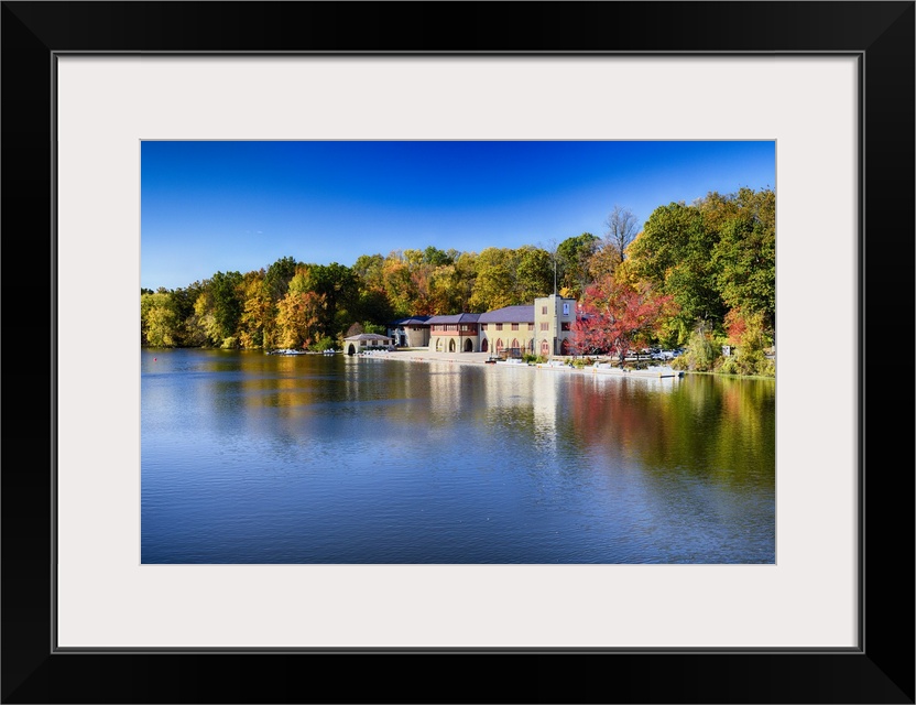 Buildings at the edge of the calm waters of Lake Carnegie in New Jersey in the fall.