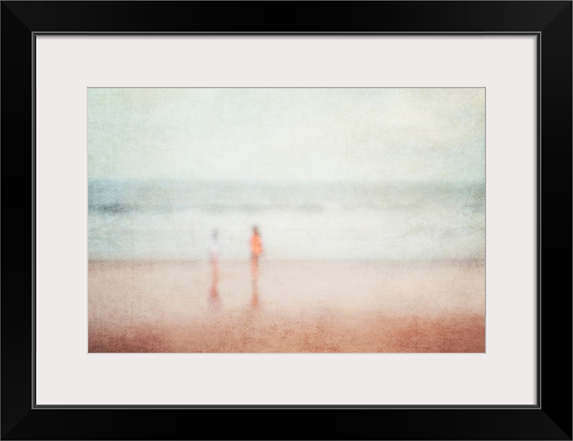 A vintage seaside holiday vacation dream image of two children playing on a beach in blurry soft focus.