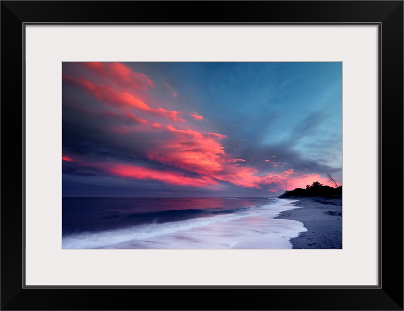 Sunset over the Atlantic ocean with brilliant red clouds over white capped waves