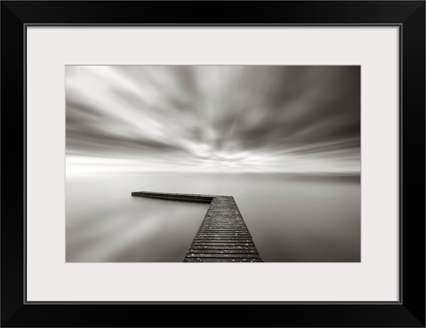 This wall art is a time lapsed photograph of this lake pier has created a sensation of motion in the sky and water which h...