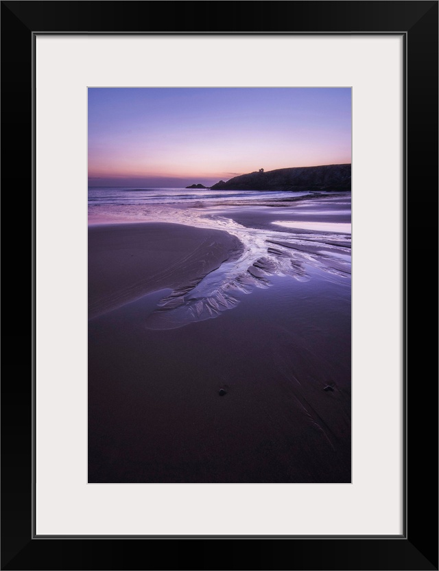 Beach at sunset in Port Blanc area in Quiberon, pink an violet colors, France, a vertical view.