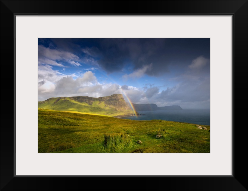 Fine art photo of lush green cliffs at the edge of the sea under a dramatic sky.