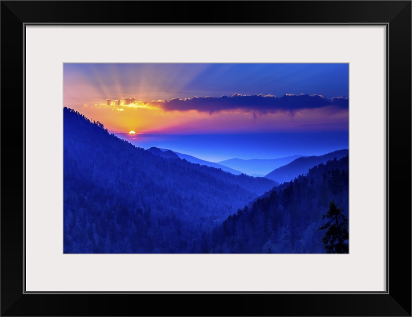 Warm rays of sunlight illuminating the deep blue sky over the Blue Ridge Mountains.