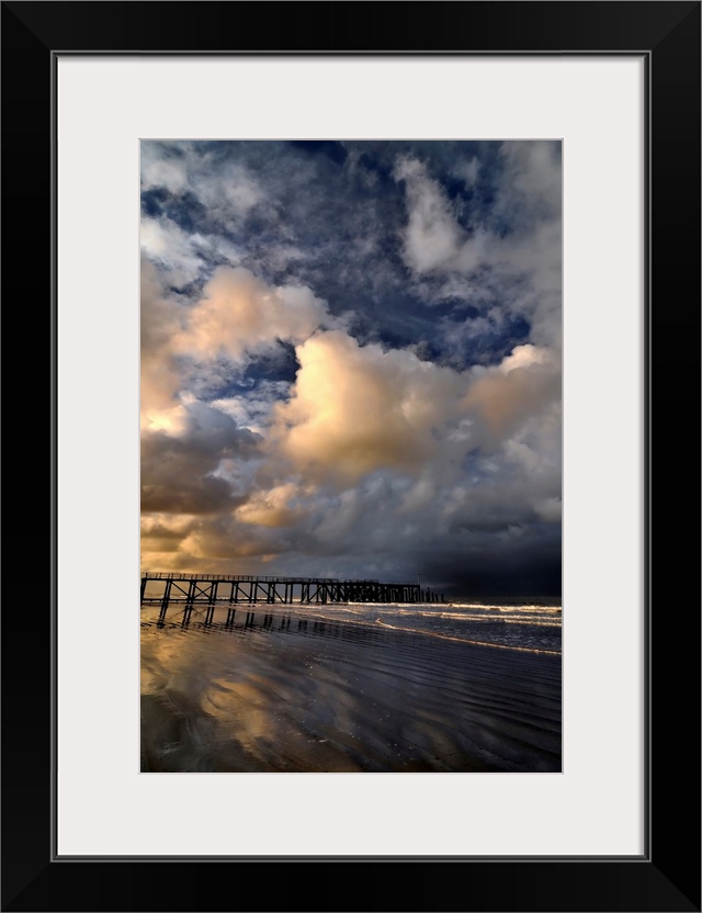 Ancient beach bridge, Estacade, going into the sea in Saint Jean de Monts city in France, vertical view with big white clo...