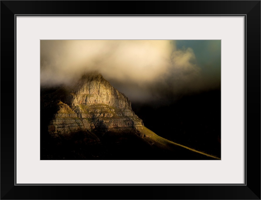 A photograph of clouds rolling over a mountain peak.