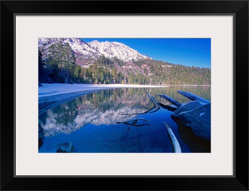 Landscape, big photograph of the still waters of Emerald Bay at Lake Tahoe, California, surrounded by a snow covered lands...