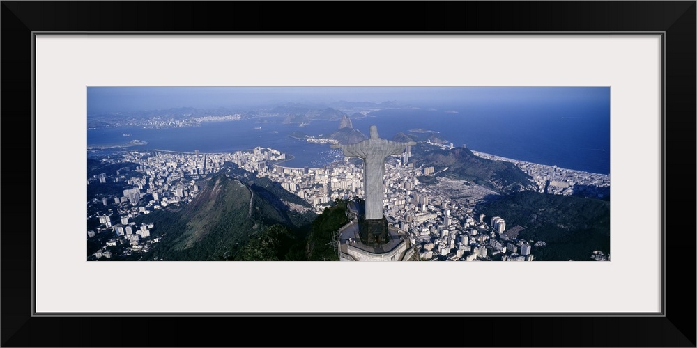 Giant, landscape photograph of the back of Christ the Redeemer statue overlooking Rio de Janeiro, Brazil.