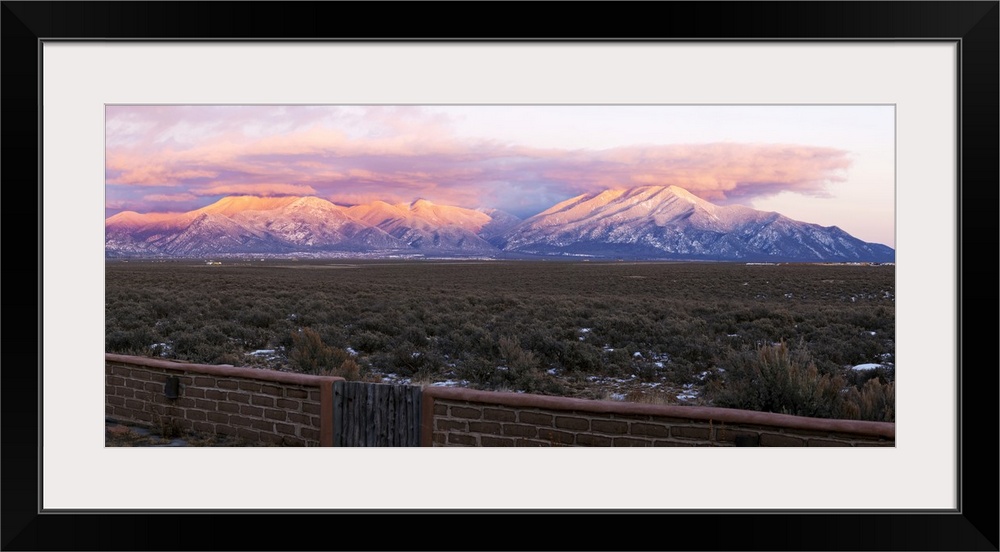 Mountain range viewed from an adobe brick wall and Sangre De Cristo Mountains, New Mexico, USA.