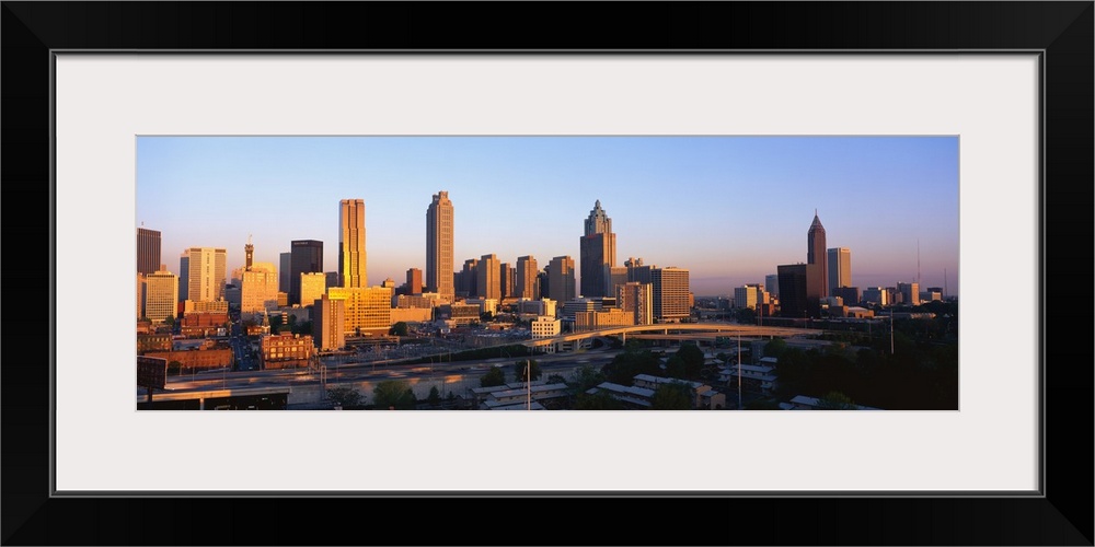 Large, panoramic photograph of the Atlanta, Georgia skyline at sunrise.