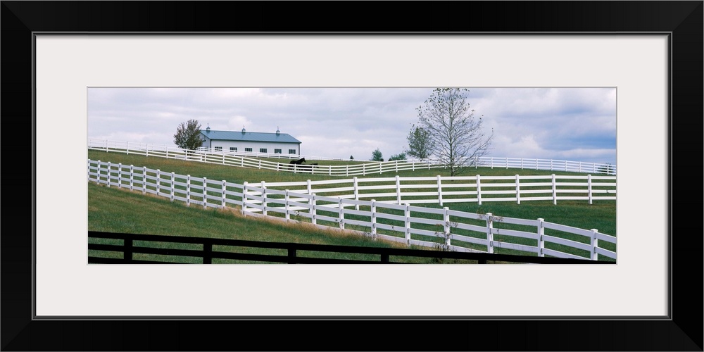 Horse corral fences and barn in Kentucky.	In Lebanon, KY a hillside of white and black fences of horse corrals and horse b...