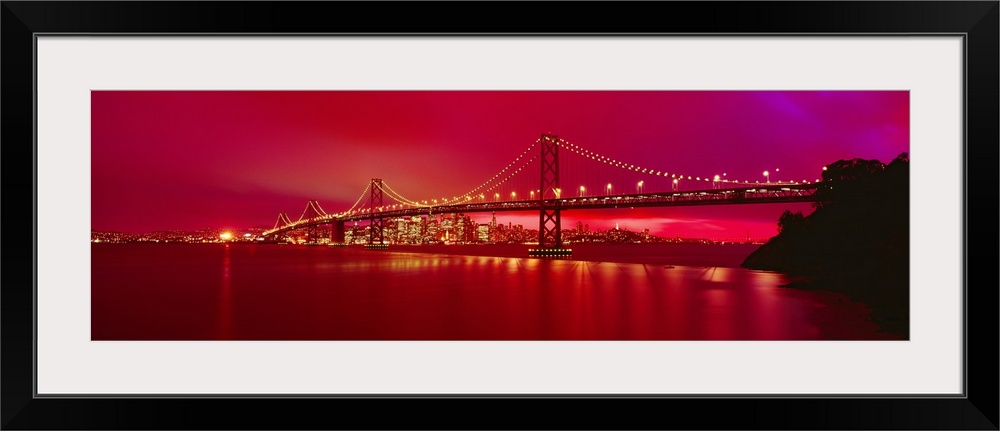 This panoramic landscape photograph was taken at just time of day to turn the sky a brilliant hot neon hue that reflects i...