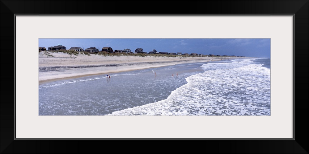 Landscape, large photograph of the shoreline at an angle on Hatteras Beach in North Carolina.  A line of beach houses can ...