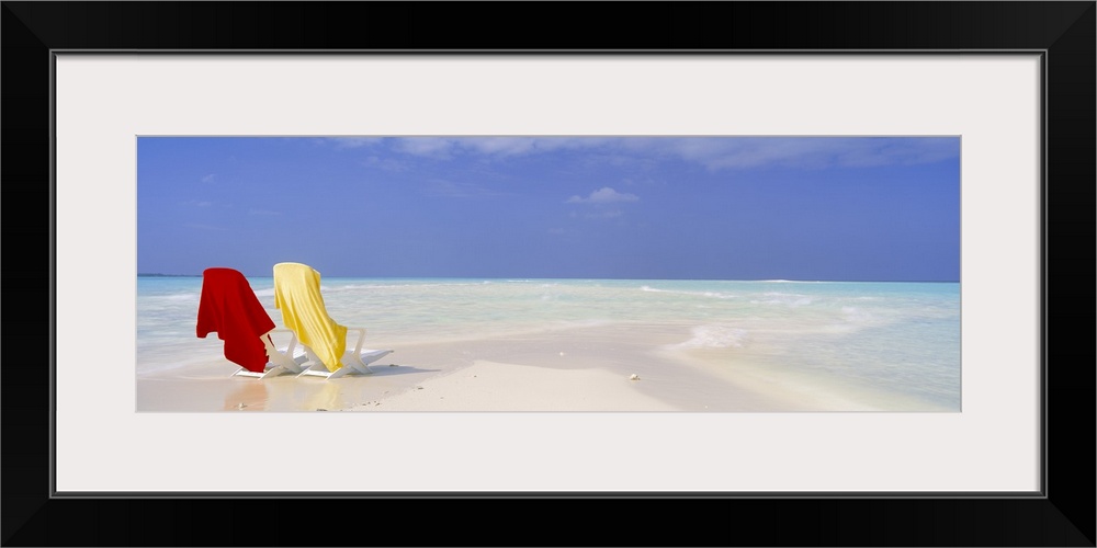 An image of two beach chairs sitting on a sandbar with clear ocean water washing up on shore nearby on canvas.