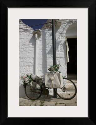 Bicycle parked against a pole, Trulli House, Alberobello, Apulia, Italy