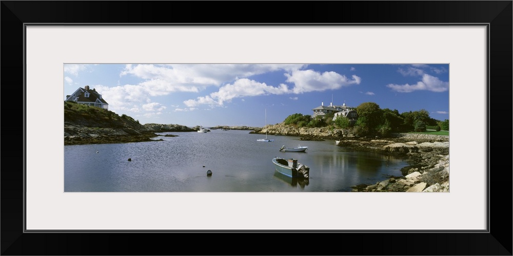 Panoramic photograph on a big canvas of several small boats in ocean water, surrounded by rocky landscape on both sides, w...