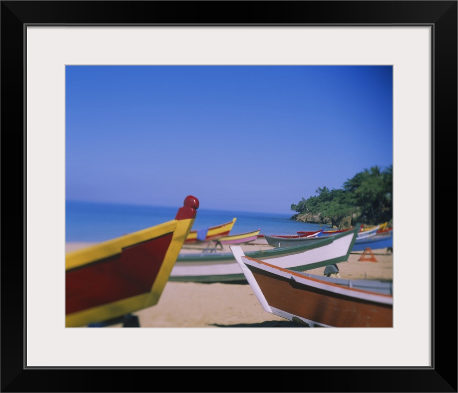 Big canvas photo of colorful wooden boats sitting on a beach with an ocean in the background.