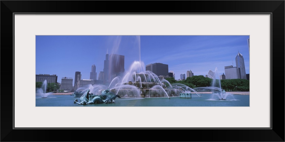 Landscape, close up photograph of Buckingham Fountain during the day, the skyscrapers of Chicago in the background, beneat...